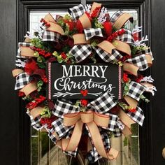 a christmas wreath with the words merry on it and red, black and white bows