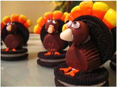 chocolate turkey cookies with candy candies in the shape of their heads and legs, on a table