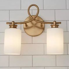 two light bathroom fixture with white glass shades on the top and bottom lights in an old - fashioned brass finish