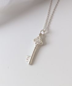 "This key pendant has been handmade using fine silver and features a trefoil shaped top set with a 2mm sparkly cubic zirconia. This pendant measures 9mm across at its widest point and is approx. 25mm in length. This pendant has been hallmarked by the London Assay Office. It is available on a 16, 18\" or 20\" sterling silver rope chain. Have a look at my necklace size guides in the product pictures to see how these sizes might fit you. Keys are one of the oldest lucky charm symbols. The giving of Silver Key Necklace For Gift, Silver Necklace With Two Keys For Gift, 21st Key, Key Locket, Silver Key Necklace, Silver Key, Luck Charm, 21st Birthday Gifts, Key Necklace