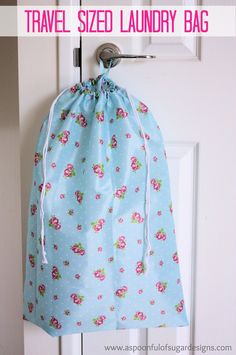 a blue bag hanging from the side of a door with pink flowers on it and text overlay that says travel sized laundry bag