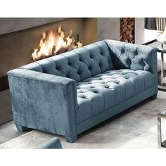 a blue couch sitting in front of a fire place