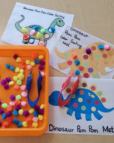 an orange tray filled with different types of toys and paper on top of a table