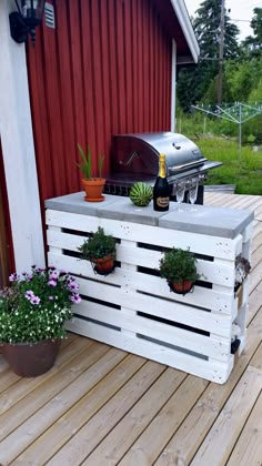 an outdoor bar made out of pallets with potted plants