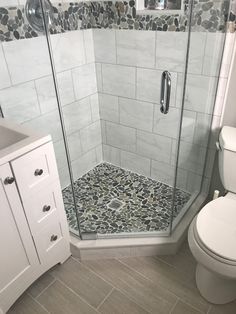 a white toilet sitting next to a walk in shower