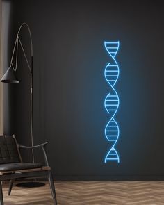 a neon blue wall hanging next to a chair in a room with a black wall and wooden floor