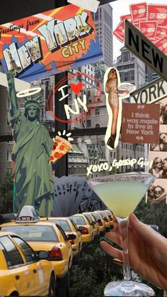 a person holding up a martini in front of the statue of liberty and taxi cabs