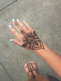 a woman's hand with a henna tattoo on it