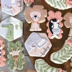 decorated cookies with animals and leaves on a wooden table next to other items that include zebras, giraffes