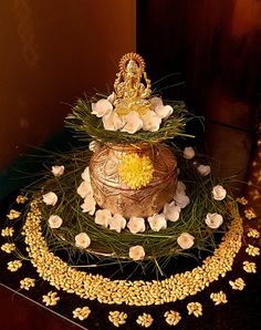 a three tiered cake decorated with flowers and a golden buddha figure on the top