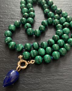 This one of a kind necklace features smooth AAA natural malachite rounds hand knotted with blue silk and finished with a 14k solid gold bolt clasp. The pendant is a beautiful AAA micro faceted lapis lazuli drop with a solid 14k gold bail. The pendant can be removed.  Necklace length approx. 18.5 " Malachite size approx. 6mm Lapis Lazuli drop size approx. 6x13mm Your necklace will arrive packed and rowdy for gifting.  Thanks for stopping by! Hand Knotted Necklace, Knotted Necklace, Lapis Lazuli Pendant, Gold Hand, Necklace Statement, Knot Necklace, Blue Silk, Necklace Length, Lapis Lazuli