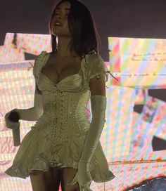 a woman in a short white dress on stage