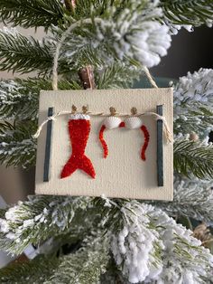 an ornament hanging from a christmas tree decorated with red and white sequins