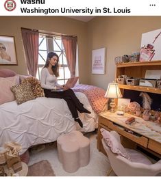 a woman sitting on top of a bed next to a desk with a laptop computer