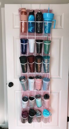 the door is open and there are cups hanging on it's side rack in front of the door