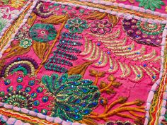 a close up view of a pink and green patchwork quilt with flowers on it