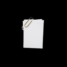 a binder with a paper clip attached to it on a black background in the dark