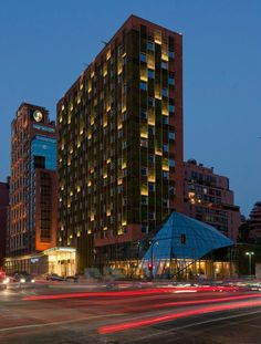 a very tall building with lots of windows and lights on it's sides at night