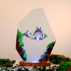 a glass trophy with an image of totoro and other animals on it's side