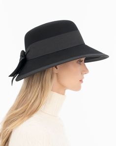 A women’s fall felt hat, trimmed with grosgrain that is timeless and chic. This is a special occasion style, not to be worn casually, which adds grace and presence. Viewed from the front, the dressy silhouette reminds one of Audrey Hepburn’s hats; a medium size brim curves gently downward .The unexpected surprise feature is the cutaway tulip shape of the brim in back, which finishes in a feminine double bow. UPF 50+ Blocks 98% UVA/UVB rays Hand blocked Elasticized inner band for comfortable fit Elegant Fitted Hats For Fashion Events, Elegant Hats For Fashion Events, Elegant Flat Brim Cloche Hat For Fall, Elegant Spring Hat For Fashion Events, Elegant Hat For Fashion Events, Elegant Wool Cloche Hat For Fall, Elegant Short Brim Felt Hat For Winter, Elegant Flat Brim Hats For Fall, Elegant Brimmed Fall Hat