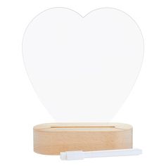 a white heart cut out on top of a wooden stand