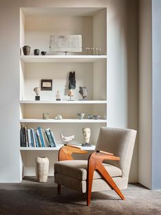 a chair sitting in front of a book shelf filled with books