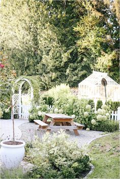 a wooden table sitting in the middle of a garden