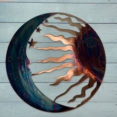 a metal sun and moon decoration on a wooden wall with white boards in the background