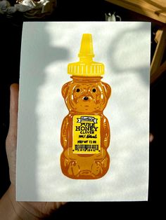 a person holding up a piece of paper with an image of a bear on it