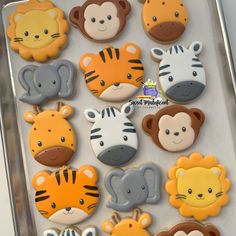 there are many decorated cookies in the shape of animals and zebras on this tray