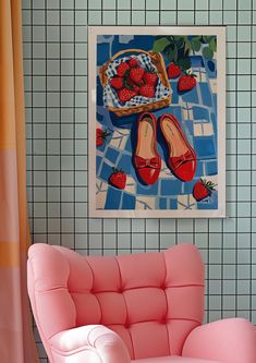 a pink chair sitting in front of a painting on the wall