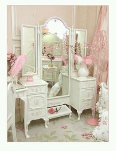 a white dresser sitting next to a mirror in a room