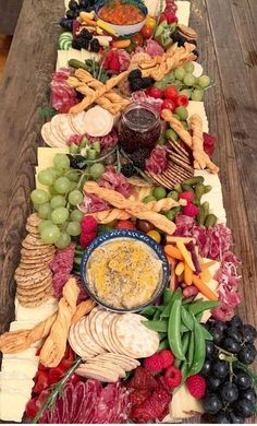 a long table covered in lots of different types of cheeses and crackers on it