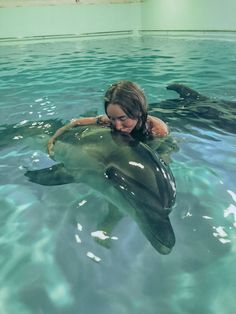 a woman is in the water with a dolphin