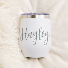 a white wine glass with the word hayley on it sitting on a fluffy blanket