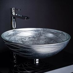 a glass bowl sink sitting on top of a black counter