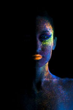 a woman's face is covered in colored powder