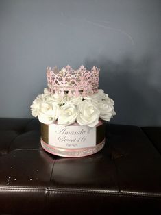 a pink and white flower box with a tiara on top