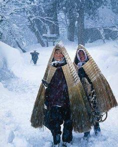 two people walking in the snow carrying baskets