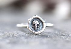 This listing is for one feminine and dainty sterling silver skull stacking ring. It features one small sterling silver skull focal fired onto 14 gauge sterling silver wire. The skull focal looks like a wax seal. It's both elegant and edgy and perfect for witchy women, men, and people who love skulls and halloween.  It looks great solo or stacked with other rings and bands. - Choose your size at check-out! - Skull measures 10mm by 10mm. - Ring band is 1 mm thick. Want to stack it with some awesom Adjustable Sterling Silver Skull Ring, Adjustable Sterling Silver Skull Ring For Anniversary, Symbolic Sterling Silver Skull Ring, Adjustable Skull Print Rings For Gift, Sterling Silver Skull Ring Stamped 925 For Promise, Adjustable Sterling Silver Skull Ring Stamped 925, Nickel-free Skull Rings For Gift, Nickel Free Sterling Silver Skull Ring, Nickel-free Sterling Silver Skull Ring