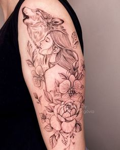 a woman's arm with flowers and a wolf tattoo on the left side of her body