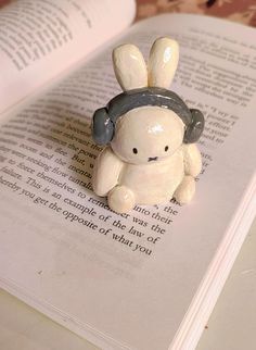 an open book with a small ceramic rabbit on it