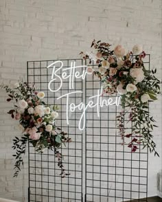 a sign that says better together with flowers and greenery on the back wall behind it