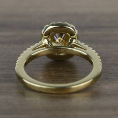 a close up of a ring on a wooden surface with a diamond in the center