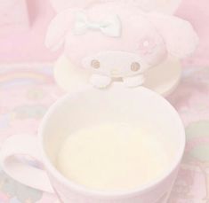 there is a cup with milk in it next to a stuffed animal