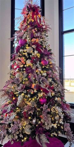 a christmas tree decorated with purple and gold ornaments