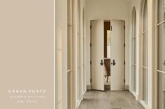 an empty hallway with white walls and wood flooring, along with arched windows on both sides