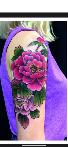 a woman wearing a purple shirt has a flower tattoo on her left arm and shoulder