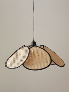 three hanging lights made out of woven material with black cords on each end and one light fixture in the middle