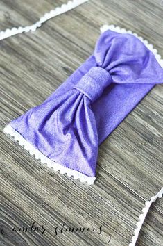 a purple bow tie sitting on top of a wooden table